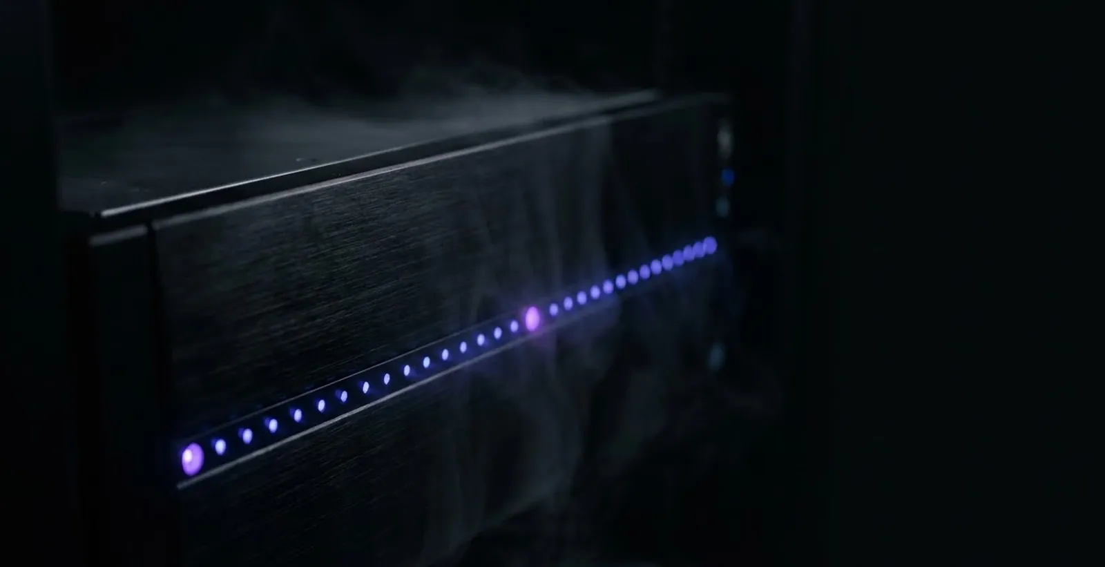 Server blades with a single row of indigo status LEDs in a dark colocation cage